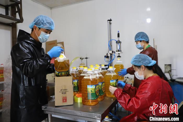 图为食用油加工企业工人加紧生产扶贫“832”平台的订单。　曾令刚 摄