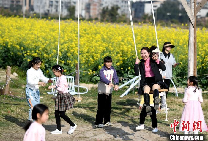 游客在油菜花海里荡秋千。　王东明 摄