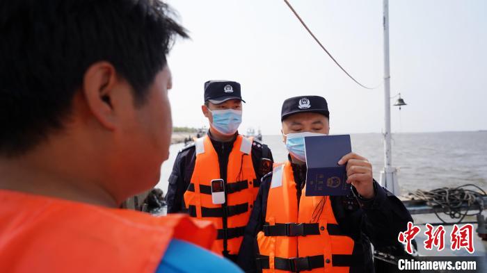 民警对货轮进行出境边防检查。