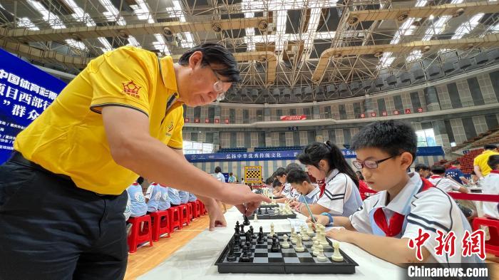 图为国际象棋男子国际特级大师叶江川与小棋手上演“一对多车轮战”表演。